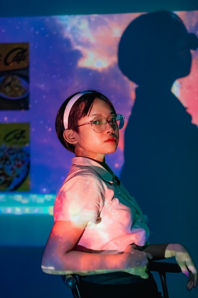 女人黑色框架眼镜和粉红色衬衫按钮
